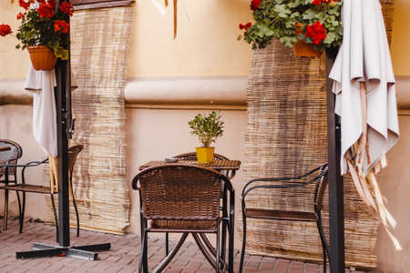 Street cafe in the old town. Empty tables and chairs. Autumn city view. Vintage style, trendy neutral colors.の写真素材