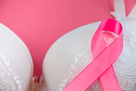 Breast Cancer Awareness Month. Women's bra and pink ribbon on bright background. Health care concept, oncology diagnostics. Cancer Fight Symbol.の写真素材