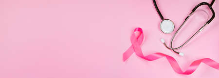 Breast Cancer Awareness Month. Pink ribbon and stethoscope on colored background. Women's health care concept. Symbol of fight against oncology. Copy space.の写真素材