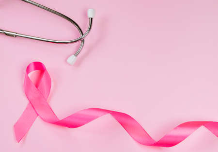 Pink ribbon and stethoscope on colored background. Breast Cancer Awareness Month. Women's health care concept. Symbol of fight against oncology. Copy space.の写真素材