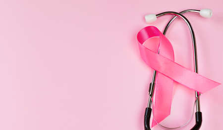 Breast Cancer Awareness Month. Pink ribbon and stethoscope on colored background. Women's health care concept. Symbol of fight against oncology. Copy space.の写真素材