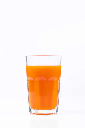 Pumpkin juice in transparent glass isolated on white background. Vegetable vegetarian drink. Healthy food and diet concept.の写真素材
