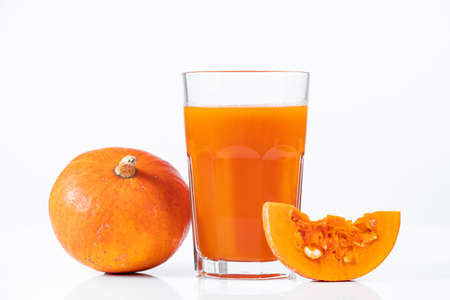 Pumpkin juice in transparent glass isolated on white background. Vegetable vegetarian drink. Healthy food and diet concept.の写真素材