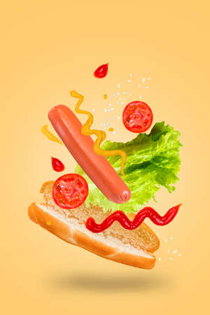 Levitating hot dog on a yellow background. Flying hotdog ingredients.の写真素材
