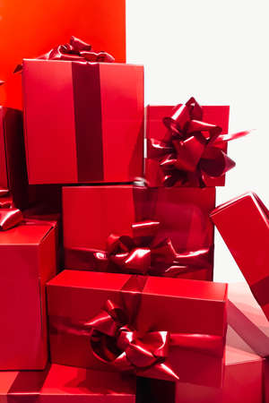 Large pile of Christmas gifts. Many red gift boxes with bows on white background. Celebration of the holiday.の写真素材