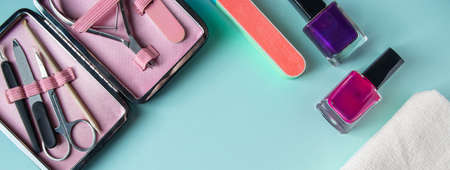 Workplace in a nail salon. A set of tools for hand care on a blue background. Place for text, banner formatの写真素材
