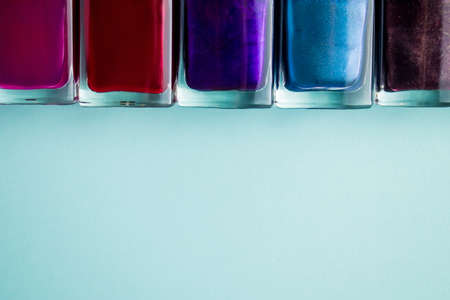 Palette of bright nail polishes on a blue background.