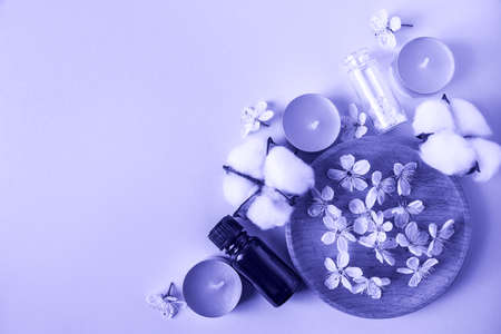 Skin care, spa and aromatherapy concept. Trendy color of the year 2022. Aroma candles and flowers for relaxation and yoga. Place for your text.の写真素材