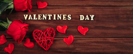 Gift boxes in craft paper and red roses on wooden background. Valentine's day, place for text....