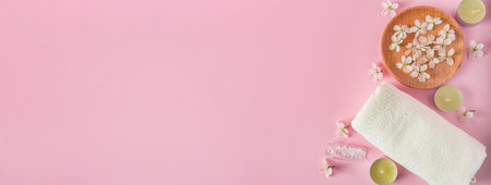 Natural cosmetic products for spa and aromatherapy. Relaxation concept. Candles, flowers and a towel on a pink background. Place for your text, banner formatの写真素材