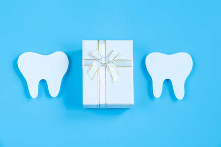 Happy International Dentist Day. Paper cut mockup of tooth and dental tool on blue background. Dental care concept. Greeting card for professional holiday. Copy space.の写真素材
