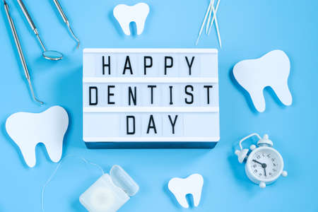 Happy International Dentist Day. Paper cut mockup of tooth and dental tool on blue background. Dental care concept. Greeting card for professional holiday. Copy space.の写真素材