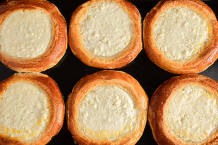 Cooking buns with cottage cheese. Homemade cheesecakes on baking sheet. Gluten free pastries. Traditional Russian or Ukrainian sweet foodの写真素材