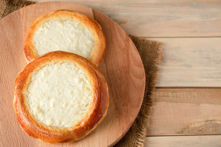 Homemade buns with cottage cheese on wooden background. Gluten free pastries. Traditional Russian or Ukrainian sweet foodの写真素材