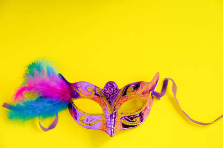Carnival mask on yellow background. Mardi Gras concept. Fat Tuesday symbol. Copy space.の写真素材