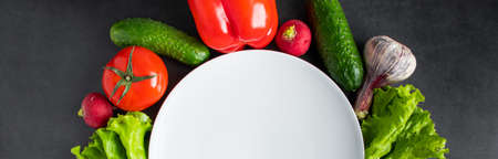 Fresh raw vegetables on a dark background. The concept of healthy eating and vegetarianism. Place...