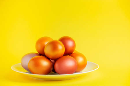 Gold glittering Easter eggs on yellow background. Happy spring holiday.