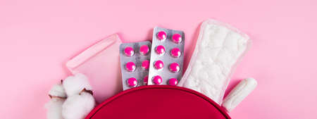 Pink cosmetic bag and set of feminine hygiene products for menstruation. Sanitary pads, tampons,...