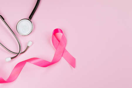 Breast Cancer Awareness Month. Pink ribbon and stethoscope on colored background. Women's health care concept. Symbol of fight against oncology. Copy space.の写真素材