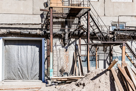 Old destroyed construction site. Rusty scaffolding and construction equipment. Industrial buildings...