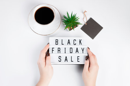 Black friday sale concept. Woman holds in her hands lightbox with text on a white background.の写真素材
