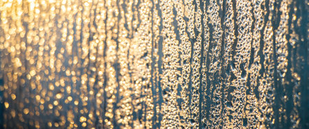 Texture of misted glass in winter. Frozen drops of water in sun on window. Dawn outside window....