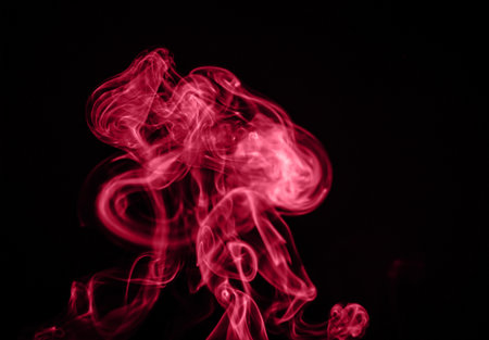 Unusual red smoke on a black background. Color of the year 2023 - Viva Magentaの写真素材