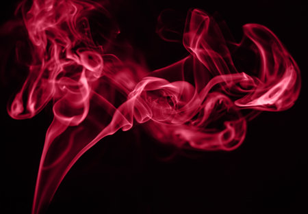 Beautiful red smoke on a black background. Color of the year 2023 - Viva Magentaの写真素材