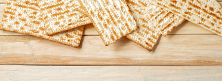 Background for the traditional Jewish holiday Pesach. Passover matzo bread on wooden table. Matzoh frame. Place for your text, banner format.の写真素材