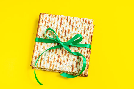 Traditional Jewish matzo on yellow background. Happy Passover. Pesach religious holiday celebration concept. Matzah bread.の写真素材