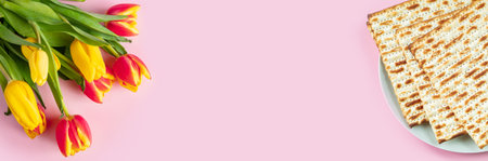 Happy Passover banner. Matzo and a bouquet of colorful tulips on pink background. Traditional Jewish food for Pesach. Copy space.の写真素材