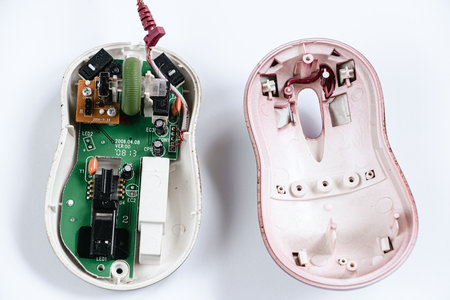 Disassembled computer mouse on white background. Gadget repair. Microchip in old computer hardware. Broken optical mouse. Copy space.の写真素材