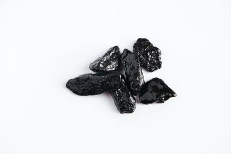 Black shiny decorative stones on white background. Natural obsidian.の写真素材