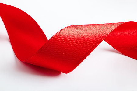 Curl of red decorative holiday ribbon isolated on white background. Silk ribbon for wrapping gifts. Element for design.の写真素材