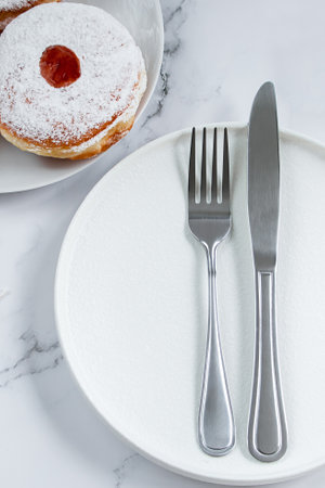 Table setting for Hanukkah Jewish holiday. Plate and cutlery on a white background. Candles, gifts...