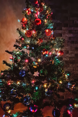 Christmas tree with multi-colored shining garland. Home decoration for holiday. Bright colored...