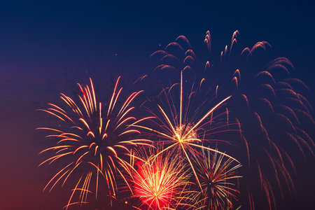 Colorful fireworks on night sky background. Celebration and holidays concept. Independence Day 4th of July, New Year, festival. Bright explosions of lights in sky. Place for your text.の写真素材