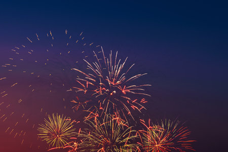 Colorful fireworks on night sky background. Celebration and holidays concept. Independence Day 4th of July, New Year, festival. Bright explosions of lights in sky. Place for your text.の写真素材