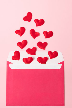 Envelope with greeting card for valentine's day. Romantic holiday concept. Hearts on pink background.の写真素材