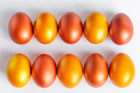 Shiny golden Easter eggs close-up on a white background. Place for text.の写真素材