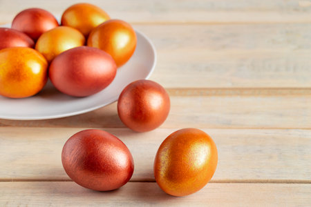Gold and bronze Easter eggs on a wooden background. Happy spring holiday.の写真素材