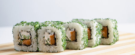 Uramaki sushi roll on wooden tray on white background. Popular Asian rice and seafood dish for eating with chopsticks. Fast delivery of Japanese takeaway food. Banner format.の写真素材