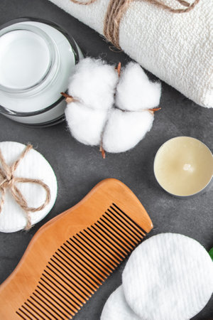 Natural body care cosmetics on concrete background. Spa accessories, towel, hairbrush, essential oil. Flat lay composition. Eco-friendly products, zero waste. Vertical photo.の写真素材
