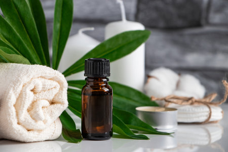 Essential oil, towel and candles on gray stone background. Spa wellness accessories and cosmetics. Face and body care concept. Beauty treatments, relaxation.の写真素材