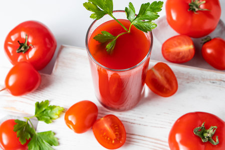 Refreshing tomato juice with parsley on a white background. Vegan vegetable smoothie.の写真素材