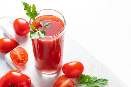 Refreshing tomato juice with parsley on a white background. Vegan vegetable smoothie.の写真素材