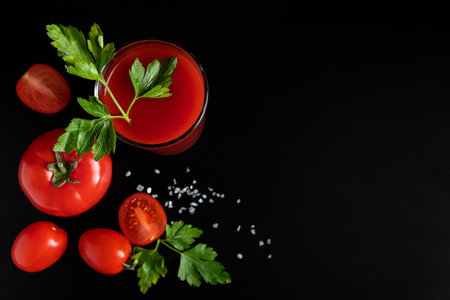 Delicious tomato juice on a black background. Vegetable drink for vegan and healthy eating.の写真素材