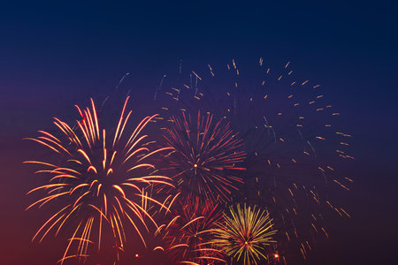 Colorful fireworks on night sky background. Celebration and holidays concept. Independence Day 4th of July, New Year, festival. Bright explosions of lights in sky. Place for your text.の写真素材