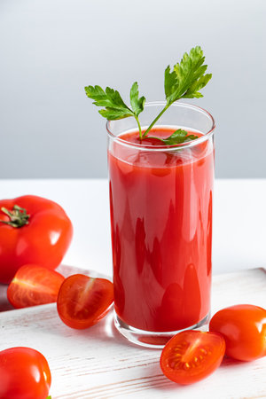 Refreshing tomato juice with parsley on a white background. Vegan vegetable smoothie.の写真素材