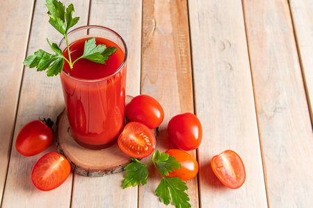 Fresh tomato juice on a wooden rustic background. Organic vegetable drink with parsley.の写真素材
